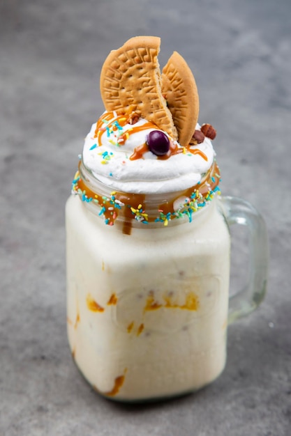 Batido con dulces y galletas en una botella de vidrio