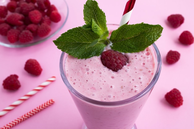 Batido de frambuesas en el vaso en rosa