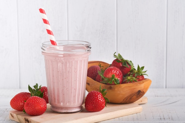 Batido de fresa Batido vegano o batido de fresa, plátano y menta sobre fondo de mesa de madera blanca Comer limpio Dieta alcalina Vista superior Maqueta