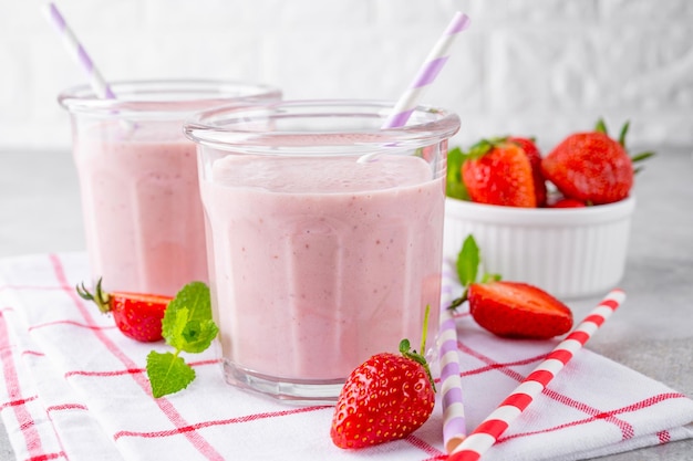 Batido de fresa o cóctel batido en el frasco de vidrio sobre un fondo de hormigón gris Copiar espacio