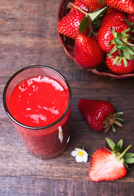 Batido de fresa en tarro de cristal sobre mesa de madera antigua