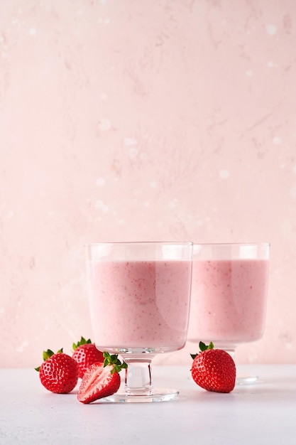 Batido de frutas. Batido de fresa o batido con bayas y menta en vaso alto sobre fondo gris claro. Batido de bebida de verano, batido y concepto orgánico de refresco. Lugar para el texto.