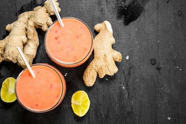 Batido de frutas con jengibre y limón sobre negro.