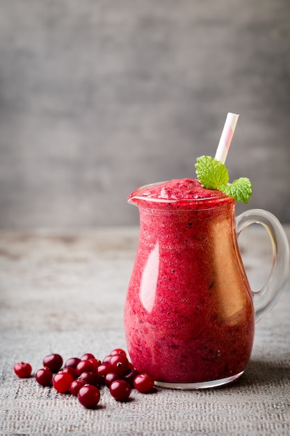 Batido, jugo de rosa sobre la superficie gris.