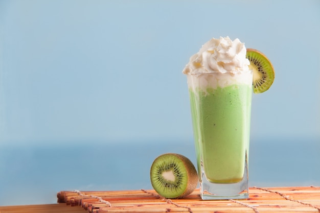 Batido de kiwi con kiwi en rodajas con mar de fondo