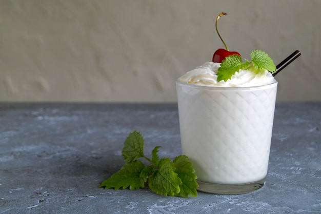 Batido De Leche Con Cerezas. sobre un fondo gris.