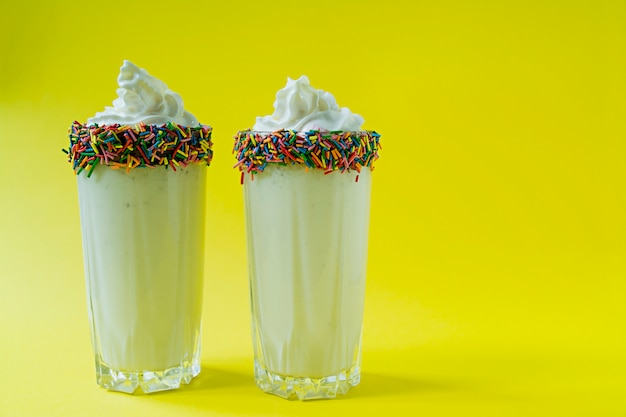 Batido de leche con helado y crema batida servido en un vaso de vidrio.