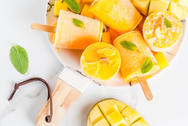 Batido de mango congelado, con hojas de menta y fruta fresca de mango