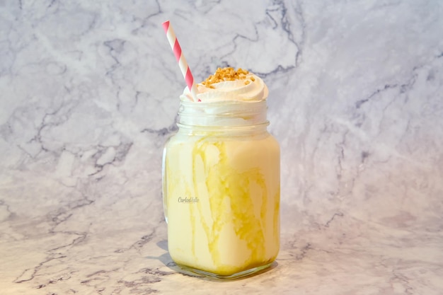 Batido de mango con crema batida en fondo de jarra de vidrio