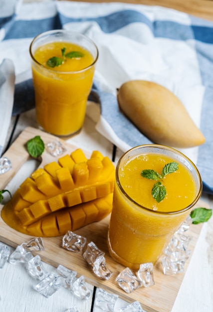 Batido de mango refrescante y saludable en un vaso con mango