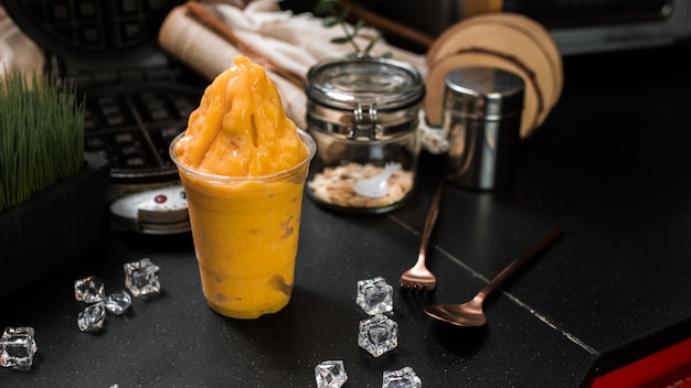 Batido de mango servido en mesa negra en cafeÃ ¢ Â € ‹