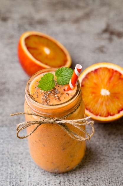 Batido, naranja roja, decoración de hojas de menta.