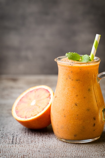 Batido, naranja roja, decoración de hojas de menta.