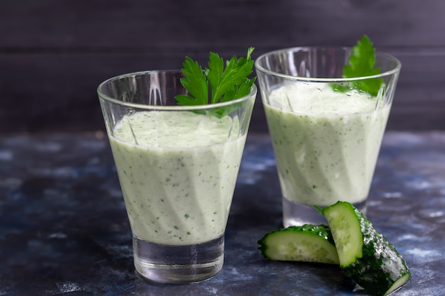 Batido con pepino, perejil y kéfir sobre una mesa oscura. Nutrición saludable, dieta.