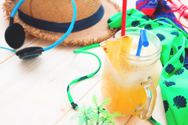 Foto batido de piña con accesorios de mujer para vacaciones de verano