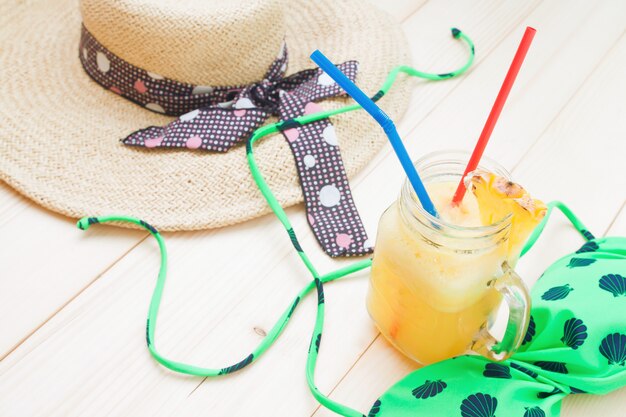 Foto batido de piña con accesorios de mujer