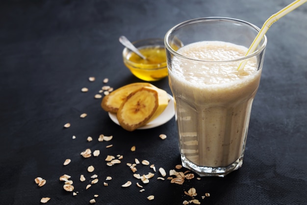 Batido de plátano con avena sobre fondo oscuro