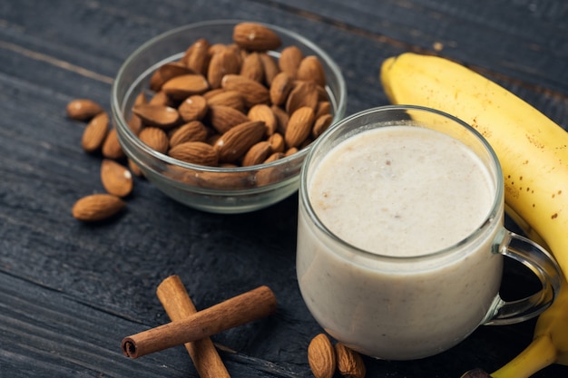 Batido de plátano fresco con almendras sobre un fondo de madera