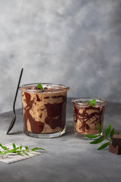 Batido de plátano con leche de coco y coco, decorado con hojas de chocolate y menta