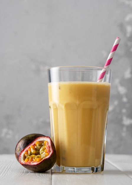 Batido de proteínas de frutas sobre una mesa de madera blanca. Batido fresco con fruta de la pasión.