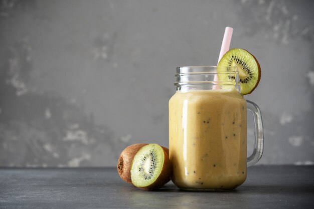 Batido de proteínas con kiwi sobre un fondo concreto. Batido de leche fresco con kiwi. Batidos