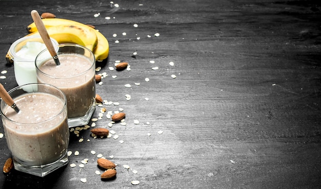 Batido de proteínas con plátano y nueces sobre fondo negro