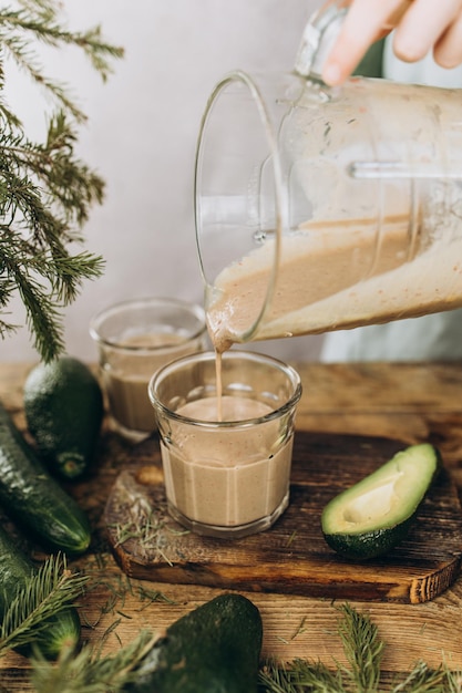 El batido recién preparado de aguacate y leche vegetal se vierte en un vaso