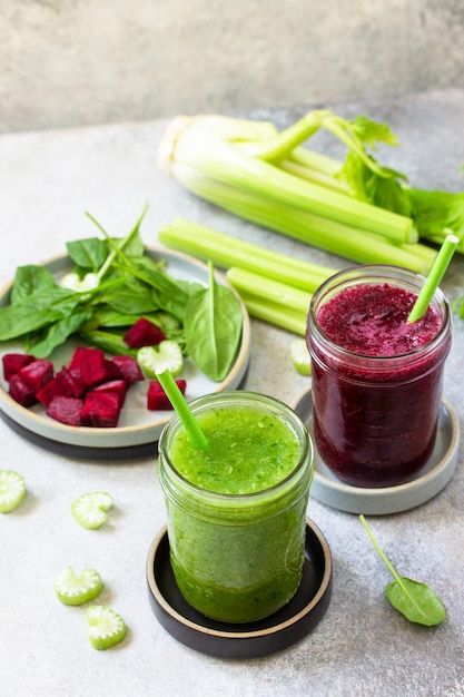 Batido de remolacha y apio batido verde y espinacas en una encimera de piedra gris Espacio de copia