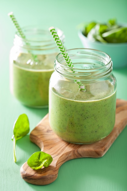 Batido saludable de espinacas verdes con mango y plátano en frasco de vidrio