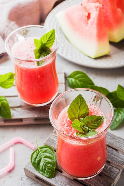 Batido de sandía fresca con hielo y hojas de menta en vasos.