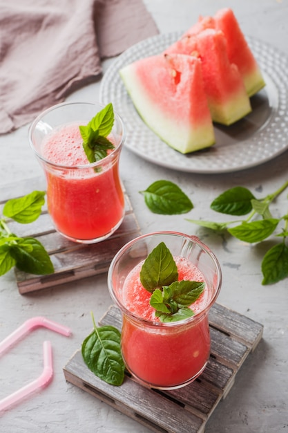 Batido de sandía fresca con hielo y hojas de menta en vasos.