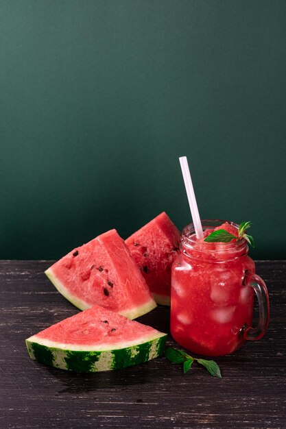 Batido de sandía fría y trozos de sandía refrescante sobre fondo oscuro Bebida fresca de verano