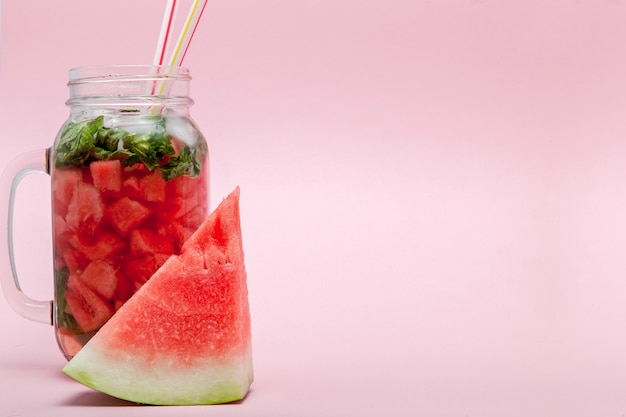 Batido de sandía con una rodaja de fruta y una hoja de menta