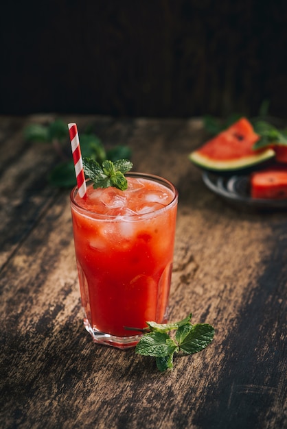 Batido de sandía y rodajas de limón sobre fondo negro