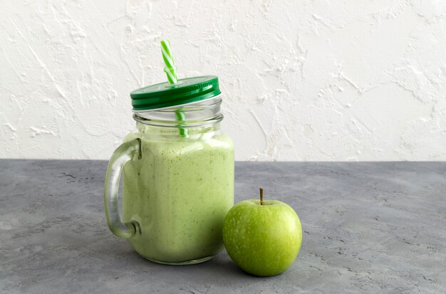 Batido saudável da desintoxicação verde em um frasco de pedreiro.