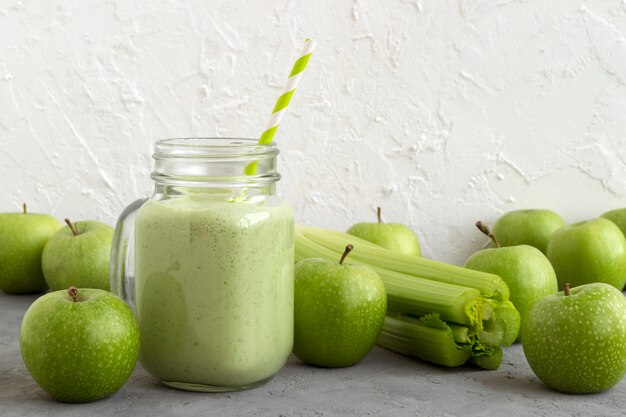 Batido saudável da desintoxicação verde em um frasco de pedreiro.