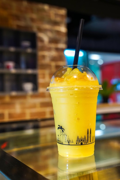 Batido de sorbete de mango en el vaso de plástico para llevar Tailandia