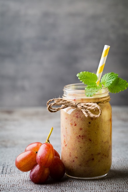 Batido de uva, sobre la superficie gris.