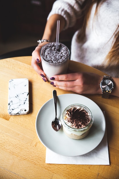 Batido en vaso de plástico sobre mesa de madera blanca