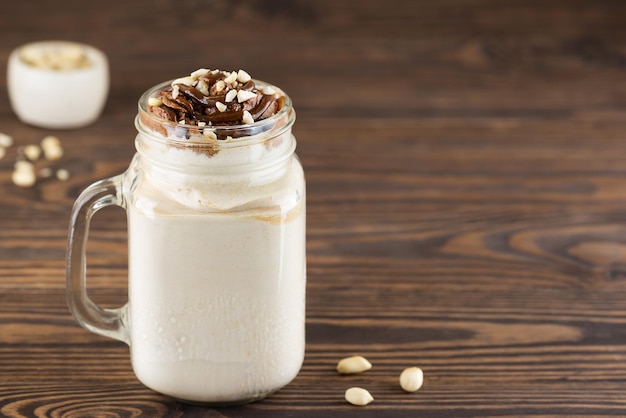 Batido vegano con chocolate y nueces en una mesa de madera Espacio de copia de orientación horizontal