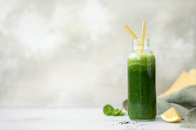 Batido de vegetales verdes y limón en una botella de vidrio