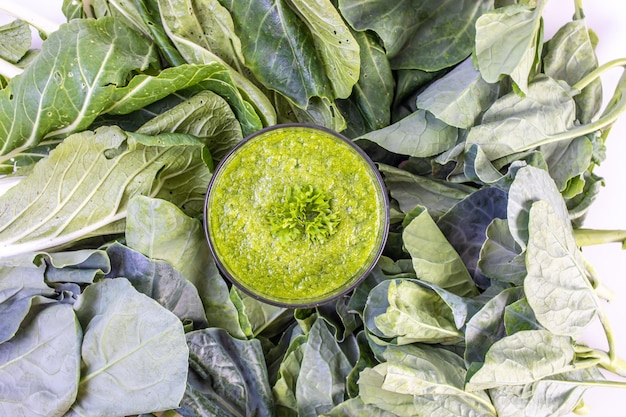 Batido de vegetales verdes saludables en un vaso aislado sobre fondo blanco de mesa