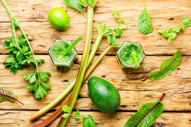 Batido vegetariano hecho de ruibarbo, limón y hierbas en la mesa de madera rústica Bebida de batido de verano.