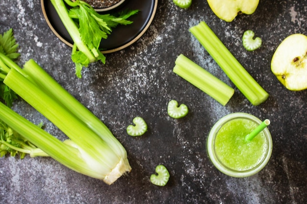 Batido verde con apio y manzana en una encimera de piedra oscura Vista superior plana