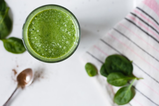 Batido verde con hierbas frescas de plátano y espinacas en la vista superior de fondo