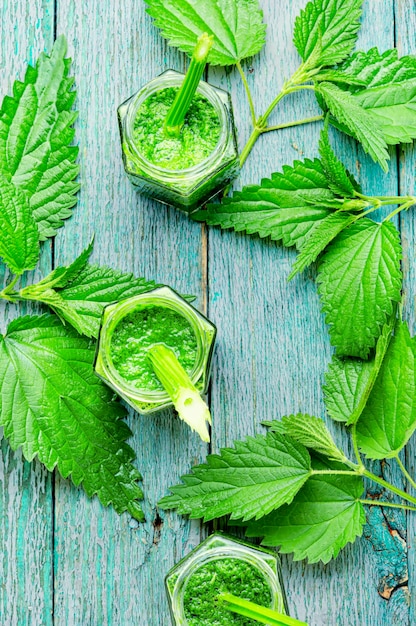 Batido verde de hojas de ortiga en frascos de vidrio. Jugos desintoxicantes