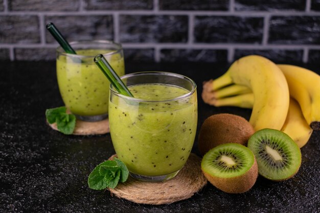 Batido verde de kiwi y plátano sobre un fondo negro