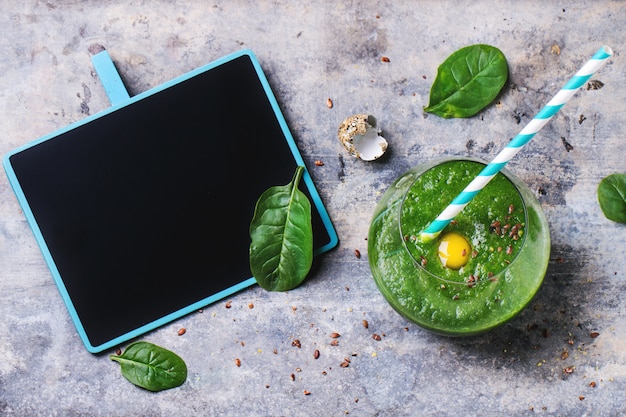 Batido verde con manzana y hojas sobre hormigón