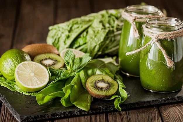 Batido verde mezclado con ingredientes en la mesa de madera enfoque selectivo alimentos saludables