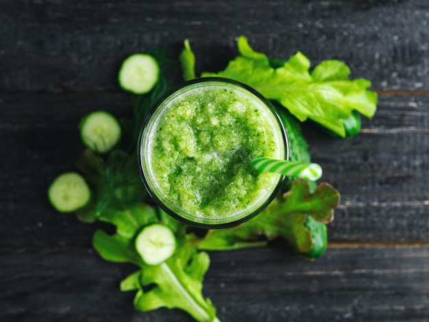 Batido verde con pepino, repollo y verduras saludables en la mesa